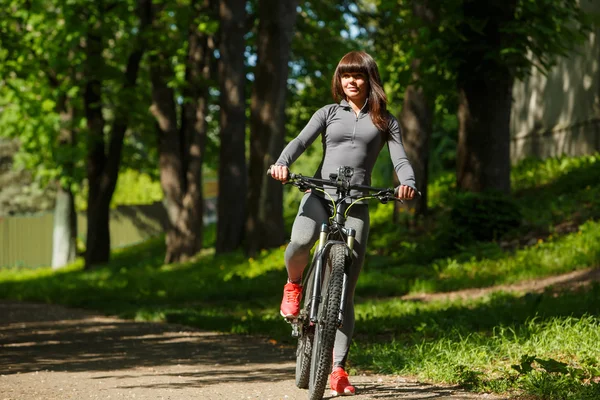 Велосипедистка на велосипеде в парке — стоковое фото