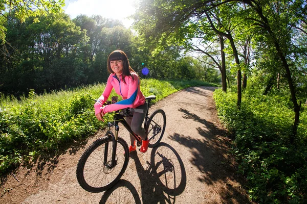 Молодая женщина развлекается катаясь на велосипеде в парке . — стоковое фото