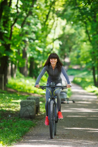 Ciclista donna in sella ad una bicicletta nel parco — Foto Stock