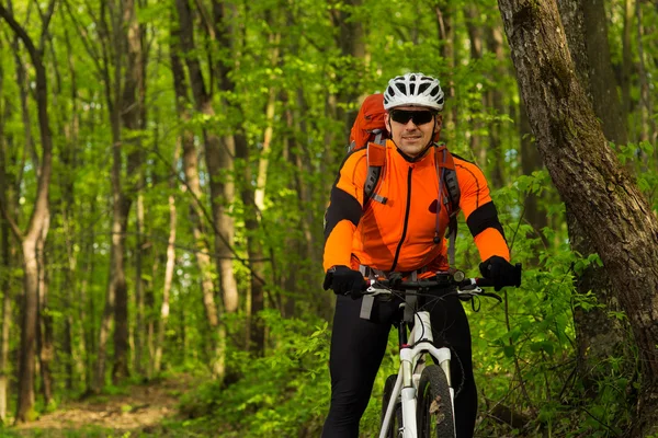 Ciclista montando a bicicleta em uma trilha na floresta de verão — Fotografia de Stock