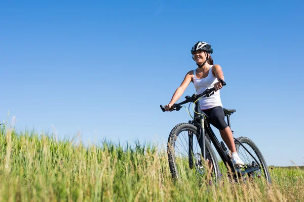 Menina monta uma bicicleta no campo — Fotografia de Stock