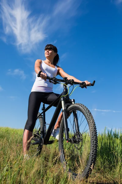 dağ bisikleti mutlu sportif kız meadows güneşli kırsal bir bölgede sakin ol.