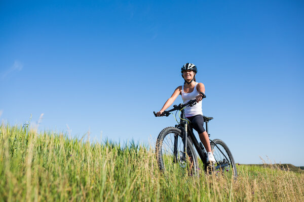 Happy Young Woman riding bicycle outside