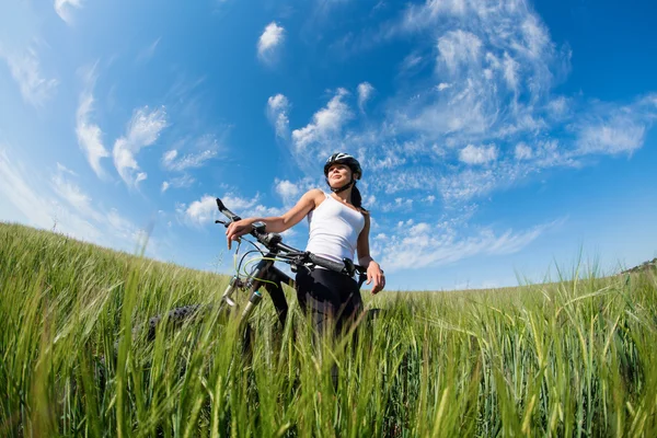Gelukkig jonge vrouw fietsten buiten — Stockfoto