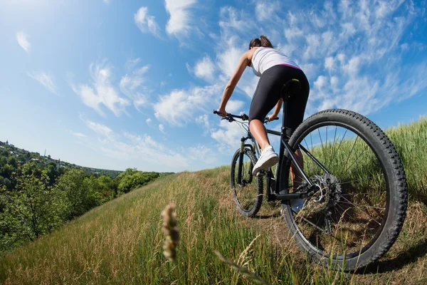 Radsportlerin auf der Wiese mit schöner Landschaft — Stockfoto