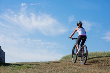 Bir bahar çayır üzerinde bisiklet ile genç bayan