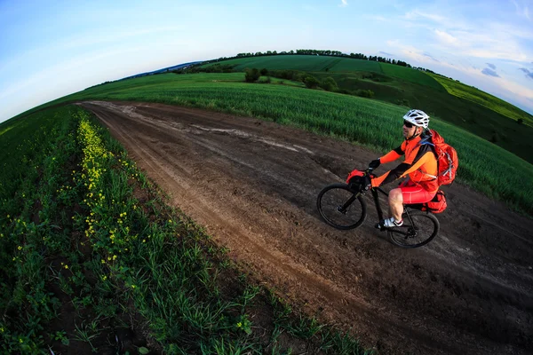 Mountain bikeer rides on the trail against beautiful sunset — Stock Photo, Image