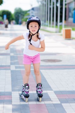 Tekerlekli paten Parkı üzerinde küçük kız rides