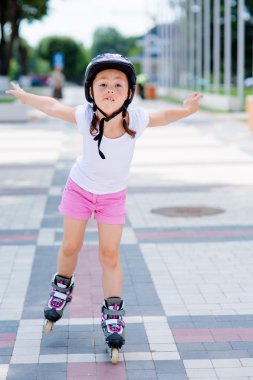 Tekerlekli paten Parkı üzerinde küçük kız rides