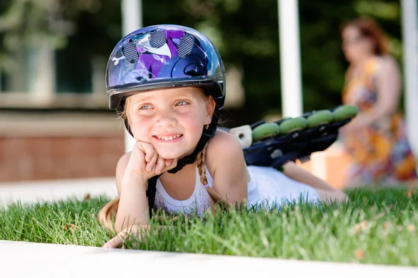잔디에 누워 파크에서 롤러 스케이트와 어린 소녀 — 스톡 사진