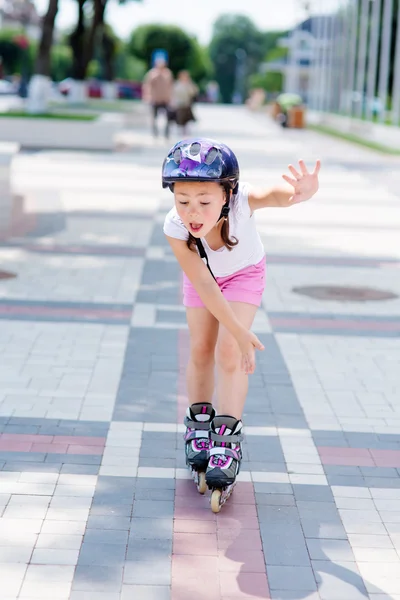 Little girl rides on roller skates at park Royalty Free Stock Photos