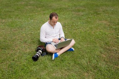 bir dizüstü bilgisayar açık havada üzerinde çalışan fotoğrafçı