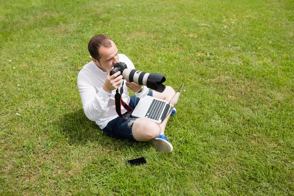 Fotograf pracuje na laptopie na świeżym powietrzu — Zdjęcie stockowe