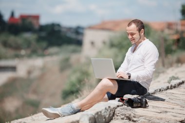 Dizüstü bilgisayarda çalışan genç başarılı erkeğin