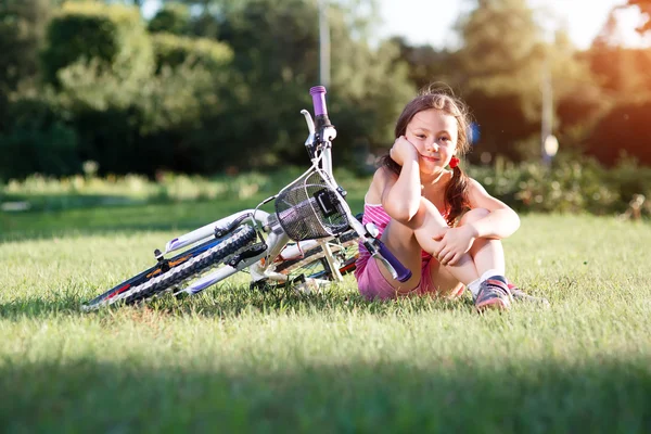 Menina feliz andar de bicicleta no pôr do sol de verão no parque — Fotografia de Stock