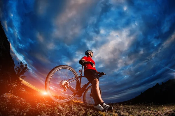 Mountain bicycle rider on the hill with sunrise background — Stock Photo, Image