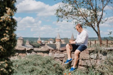 Çekici bir adam parkta dizüstü bilgisayar ile çalışma.