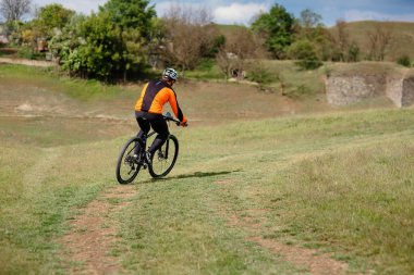 Genç adam Gezgin kırmızı sırt çantası ile bisiklet sürme