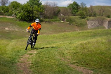 Genç adam Gezgin kırmızı sırt çantası ile bisiklet sürme