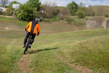 Genç adam Gezgin kırmızı sırt çantası ile bisiklet sürme