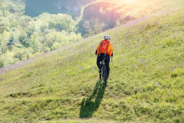 Genç adam Gezgin kırmızı sırt çantası ile bisiklet sürme