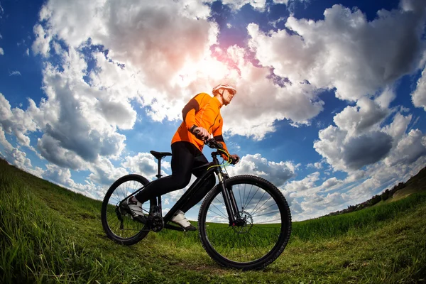 Велосипедист в красном спортивном снаряжении и шлеме — стоковое фото