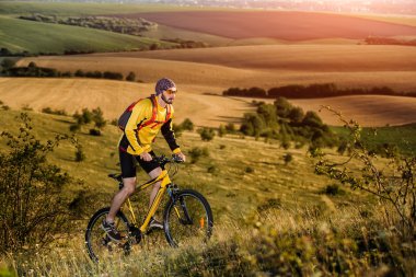 Genç adam kırsal bir yolda Bisiklete binme