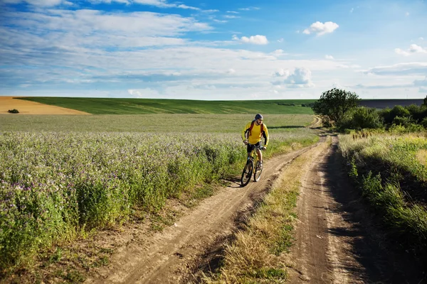 Joven ciclismo en una carretera rural — Foto de Stock