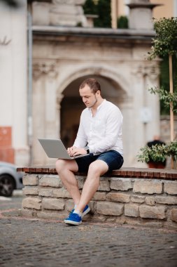 Ahşap Bank açık havada, dizüstü bilgisayarda çalışan adam