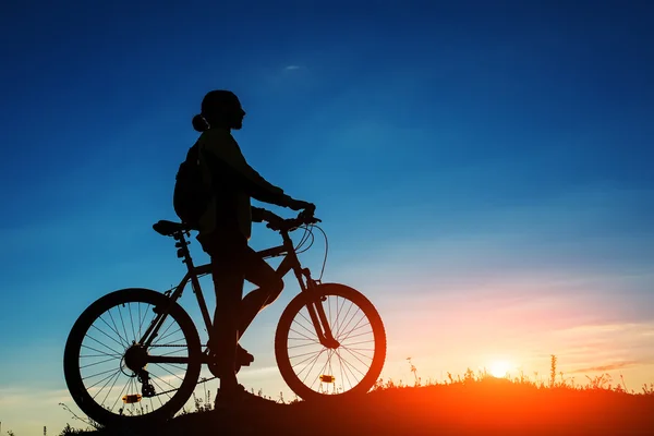 Silhueta de ciclista e uma bicicleta no fundo do céu — Fotografia de Stock