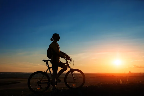 Silhouette eines Radfahrers und eines Fahrrads auf Himmelshintergrund — Stockfoto