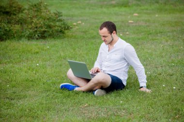 dizüstü bilgisayar açık olan genç adam