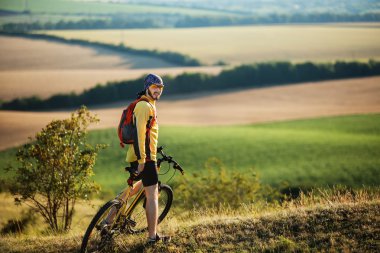 Genç adam kırsal bir yolda Bisiklete binme