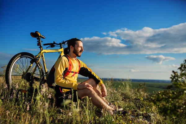 Jongeman fietsen op een landelijke weg — Stockfoto