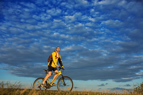 若い男が田舎の道サイクリング — ストック写真