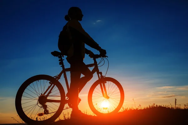 骑自行车的人和一辆自行车上天空背景的剪影 — 图库照片