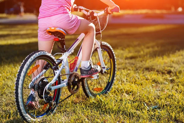 Lille pige på cykel i sommerparken - Stock-foto