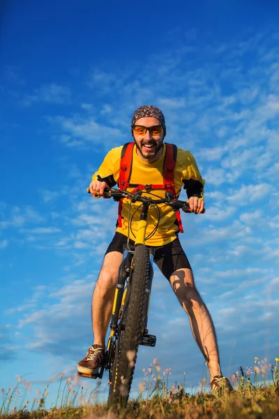 Человек в шлеме и очках остается на велосипеде — стоковое фото