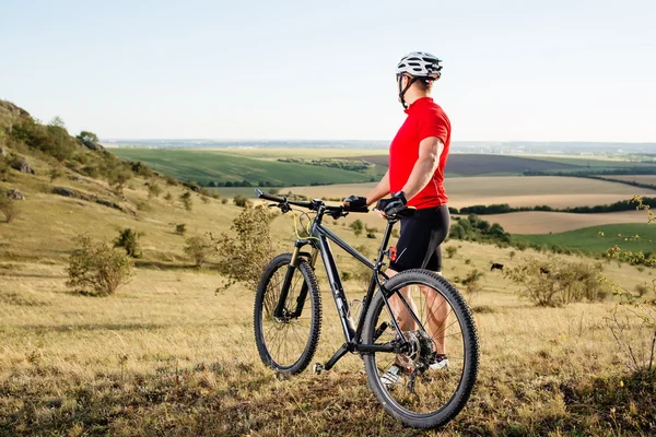 Retrato del joven ciclista con su bicicleta de montaña al aire libre — Foto de Stock