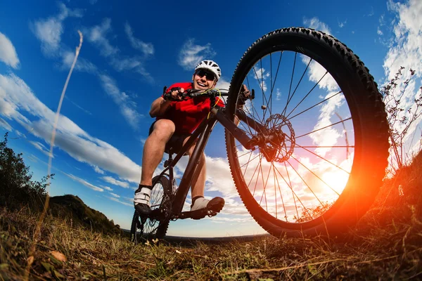 Ciclista montar en bicicleta de montaña en el camino rocoso al amanecer —  Fotos de Stock