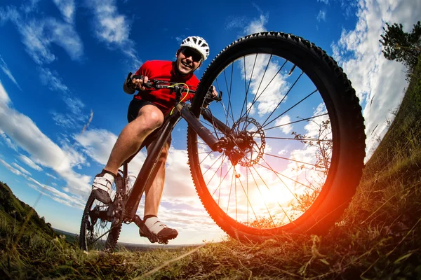 日出时的岩石小路上骑自行车的人骑山地自行车 — 图库照片