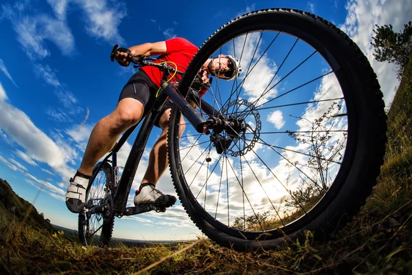 Ciclista andar de bicicleta de montanha em trilha rochosa ao nascer do sol — Fotografia de Stock