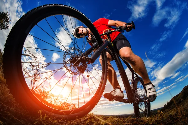 Ciclista in mountain bike sul sentiero roccioso all'alba — Foto Stock