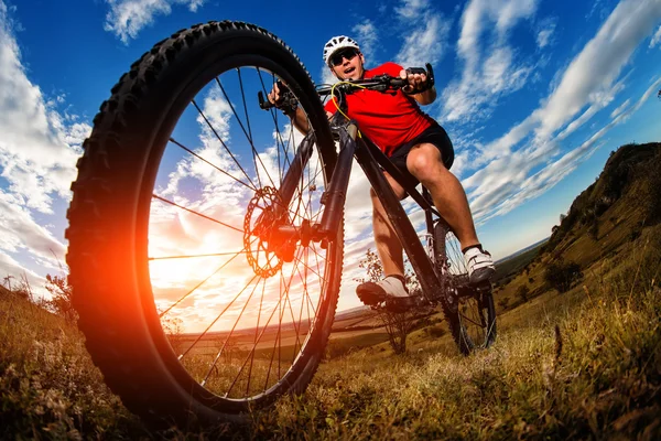 Radler fährt Mountainbike auf felsigem Weg bei Sonnenaufgang — Stockfoto