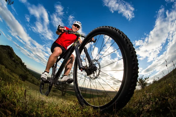 Radler fährt Mountainbike auf felsigem Weg bei Sonnenaufgang — Stockfoto