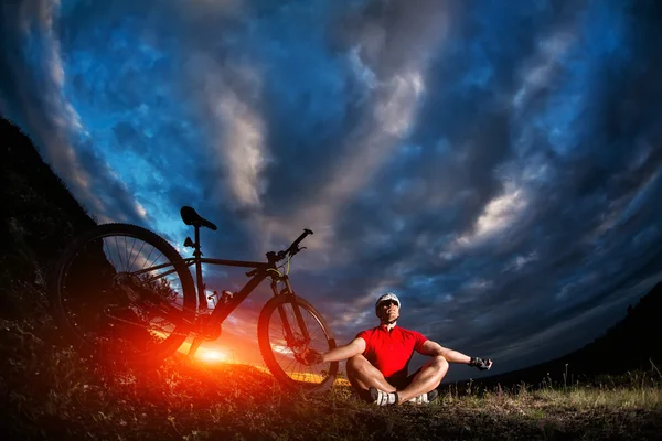 Man heeft een rust zit in de buurt van zijn fiets — Stockfoto