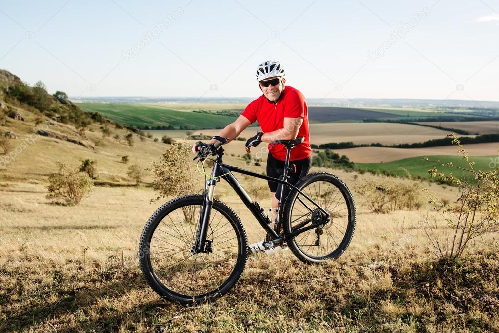 portrait of young cyclist with his mountain bike bicycle outdoors