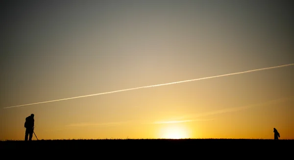 Silueta de un fotógrafo al atardecer . — Foto de Stock