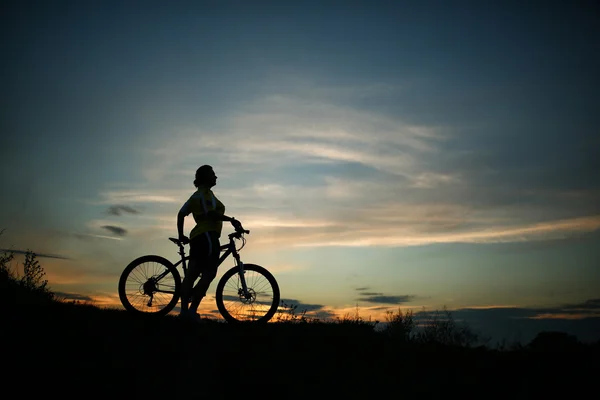 Silhueta de turista e bicicleta no fundo do céu . — Fotografia de Stock