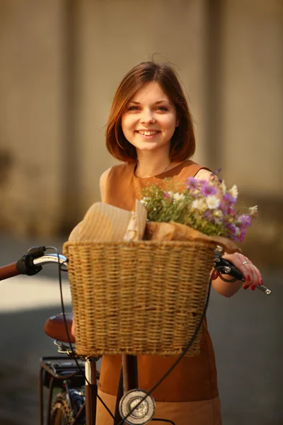 Ganska ung kvinna med cykel i parken — Stockfoto